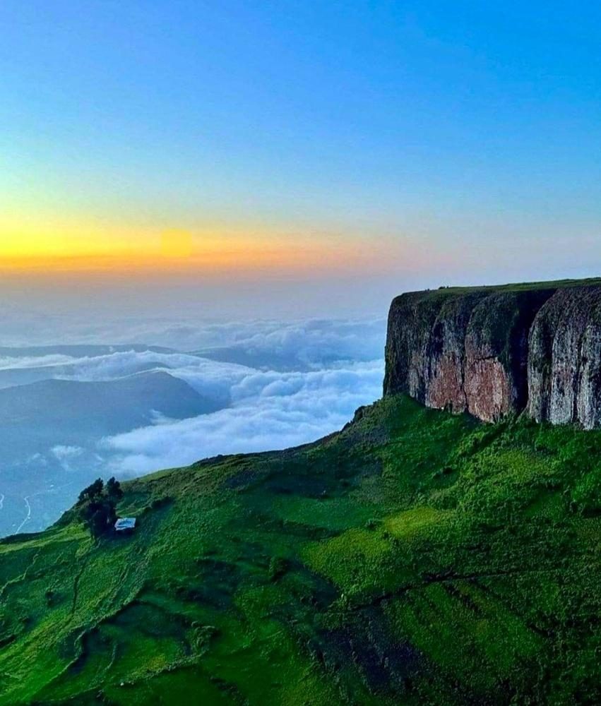 Sunrise above the clouds beside a highland cliff
